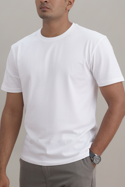 Man wearing a plain white t-shirt and gray pants against a neutral background